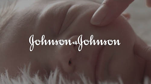 Close-up of a smiling baby lying down with Johnson & Johnson logo overlay.